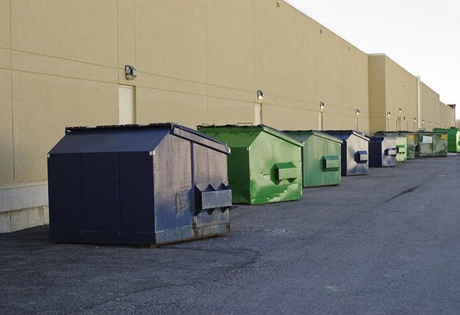 a waste management truck unloading into a construction dumpster in Buckeye, AZ